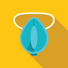 Blue oxygen mask hanging on yellow wall with long shadow