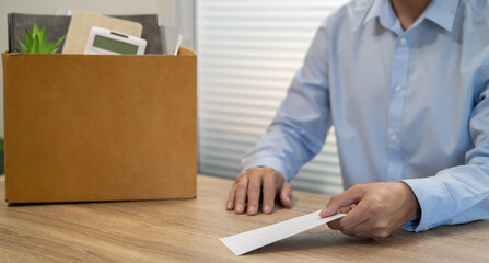 sending resignation letter to boss and Holding Stuff Resign Depress or carrying cardboard box by desk in office