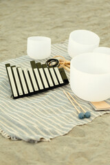 Sound bath instruments on a striped cloth mat.