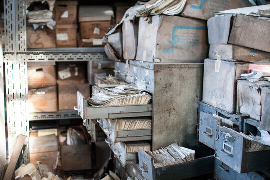Abandoned archive room with open, rusty file cabinets