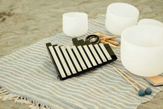Sound bath instruments on a striped cloth mat.