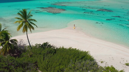 Tropical island sand beach with palm trees, coral reef, crystal turquoise water. Woman active sport relax and enjoy yellow kayak. Summer holiday vacation. Beautiful exotic nature. Aerial drone shot