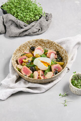 Fresh nicoise Salad with Poached Egg on Rustic Background