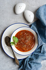 Bowl with tomato soup served on the concrete table