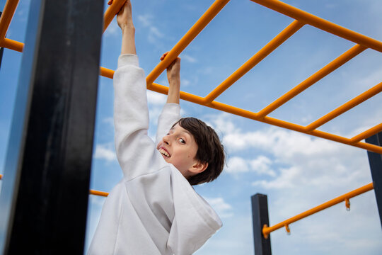 Cheerful Child playing on playground fun on monkey bars
