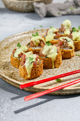 Delicious Tempura Roll with Tuna Tartare and Wasabi Mayo Sauce on Ceramic Plate