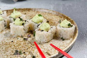Close-Up Shot of Sushi Rolls with Wasabi Sauce on Ceramic Plate – Japanese Cuisine