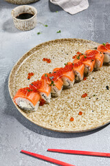 Salmon and Red Caviar Roll with Microgreens on a Ceramic Plate