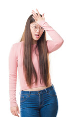 Young Chinese woman over isolated background wearing glasses surprised with hand on head for mistake, remember error. Forgot, bad memory concept.