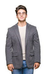 Young business man wearing glasses over isolated background Relaxed with serious expression on face. Simple and natural looking at the camera.