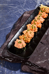 Assorted Spicy Sushi Rolls on Dark Slate Plate with Microgreens