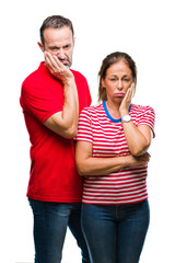 Middle age hispanic couple in love over isolated background thinking looking tired and bored with depression problems with crossed arms.