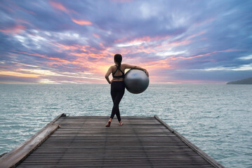 Fototapeta premium Young healthy woman practicing yoga on the bridge in the nature