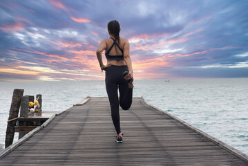 Fototapeta premium Young healthy woman practicing yoga on the bridge in the nature