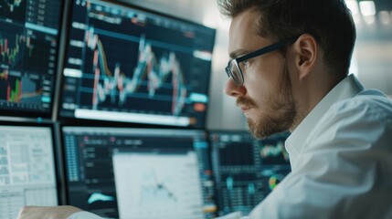 A financial analyst working on a computer with multiple screens displaying stock charts and data