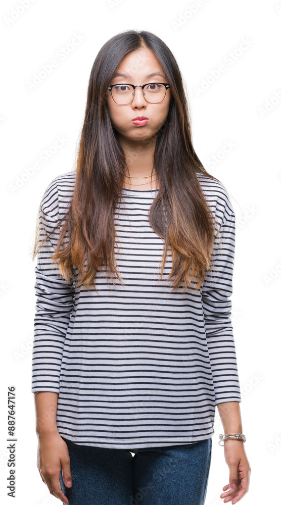 Canvas Prints Young asian woman wearing glasses over isolated background puffing cheeks with funny face. Mouth inflated with air, crazy expression.