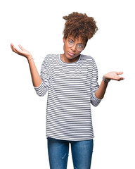 Beautiful young african american woman wearing glasses over isolated background clueless and...