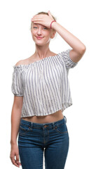 Fototapeta premium Blonde teenager woman wearing a bun stressed with hand on head, shocked with shame and surprise face, angry and frustrated. Fear and upset for mistake.