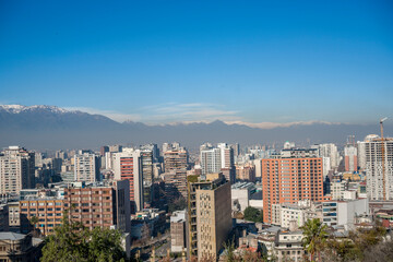 Fototapeta premium Distant snow-capped Andes mountain range beyond urban skyline.