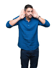 Fototapeta premium Young handsome man over isolated background Trying to hear both hands on ear gesture, curious for gossip. Hearing problem, deaf