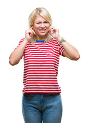 Young beautiful blonde woman over isolated background covering ears with fingers with annoyed expression for the noise of loud music. Deaf concept.