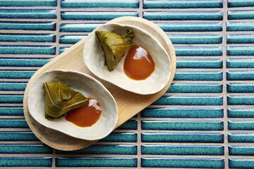 A sweet cake or candy of sticky rice wrapped in banana leaf. A traditional malaysian, thai, vietnamese or japanese dessert.