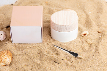 A plain box is placed on sandy beach with seashells surrounding it, creating a minimalistic yet eye-catching composition suitable for various purposes.