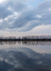 a beautiful reflection of the sky and clouds in the lake at sunset