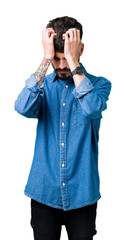Young handsome man over isolated background suffering from headache desperate and stressed because pain and migraine. Hands on head.