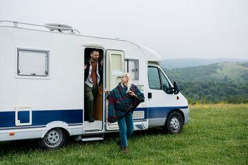 Couple Stepping Out of Camper Van into Nature