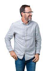 Handsome middle age elegant senior man wearing glasses over isolated background looking away to side with smile on face, natural expression. Laughing confident.