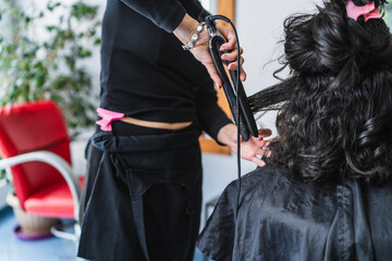 Hairdresser Using Flat Iron on Client's Hair in a Bright Salon