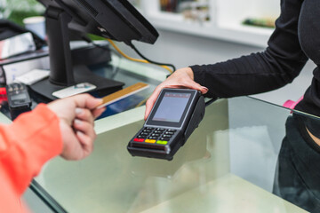 A woman is paying for something at a store using a card reader