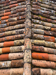 Rows of weathered, terra cotta roof tiles on an external roof