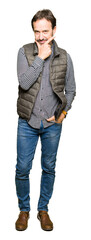Fototapeta premium Middle age handsome man wearing winter vest looking confident at the camera with smile with crossed arms and hand raised on chin. Thinking positive.