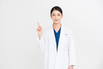 女性医師が指差しをしている。/スタジオ撮影白背景、ジェスチャー
