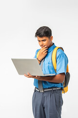 Indian Asian student in school uniform, holding laptop, isolated on white background, education concept