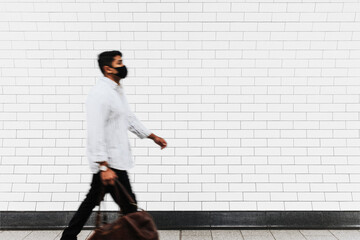 Wall mockup png with a man walking past in the new normal © Rawpixel.com