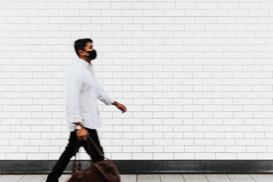 Wall mockup png with a man walking past in the new normal