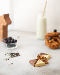 High Key Vertical Photo of Milk Bottle with Cookies, Blueberries, and Assorted Chocolates. High quality photo