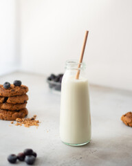 High Key Photo. Milk Bottle with Cookies and Blueberries on Concrete Background. High quality photo