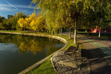 Obraz premium Park at sunrise with beautiful autumn colors and lake in background