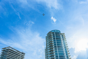 Passenger plane high above two apartment tower buildings