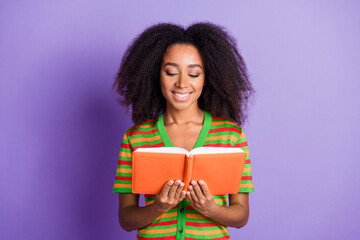 Photo of charming positive woman wear striped shirt reading book empty space isolated violet color background