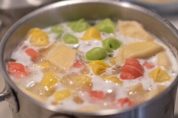 In a pot, colorful dumplings are being boiled. Preparing lunch or dinner for children and family.