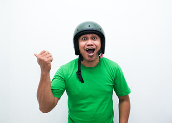 A man wearing motorcycle helmet smiling and pointing beside him