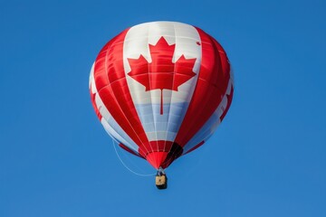 Obraz premium A hot air balloon emblazoned with the Canadian flag soars gracefully against a clear blue sky.