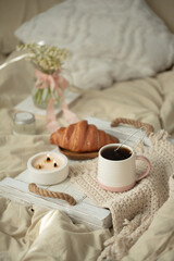 Breakfast in bed croissants and warm tea on a tray
