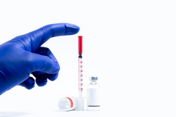 Medical vials and syringe with blue gloves on white background