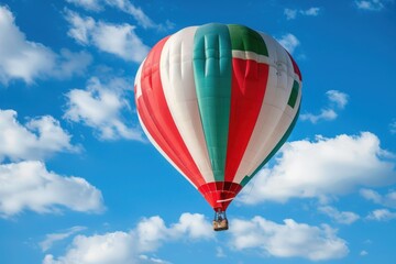 Obraz premium A vibrant hot air balloon adorned with the colors of the Italian flag ascends gracefully against a backdrop of fluffy white clouds and a clear blue sky.